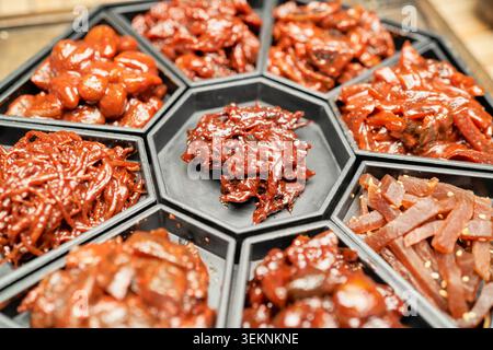 Sono presenti autentico gochujang Sunchang e vari jangajji piccanti. I primi piani mostrano la pasta di peperoncino rosso lucido servita sul riso bianco fumante. Foto Stock