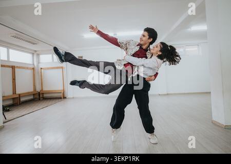 Giovane danza che pratica un passaggio in uno studio vuoto durante una sessione di prove Foto Stock