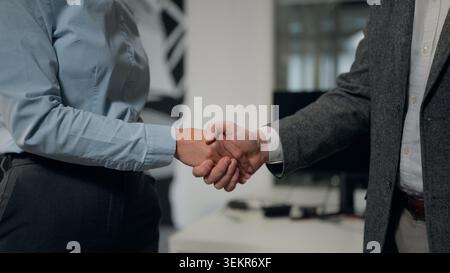 Stretta di mano d'affari donna con uomo stretta di mano in collaborazione con uffici aziendali assumendo lavoro due partner irriconoscibili donna con uomo Foto Stock