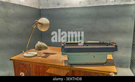 Macchina da scrivere vintage e telefono rotante sulla scrivania in interni d'ufficio retrò Foto Stock