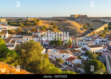 Castro Marim, Portogallo, 29 agosto 2025. Una vivace folla si riunisce nella storica città di Castro Marim, in Portogallo, mentre la luce dorata illumina il fortr Foto Stock
