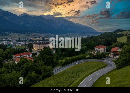 Vista aerea con drone della valle dell'Inn a Innsbruck, Tirolo, Austria, catturata al tramonto con la silhouette della catena montuosa del Karwendel e del Nordkette Foto Stock