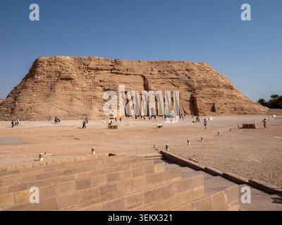 Turisti che visitano l'antico complesso di templi scavati nella roccia egizia dedicato alla regina nefertari Foto Stock