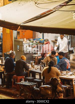 La gente del posto mangia in uno Street Food Stall nel mercato di Delhi Foto Stock