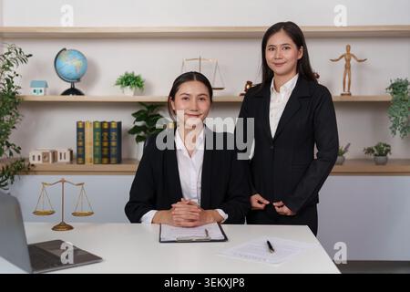 Due donne asiatiche avvocati in posa in un moderno studio legale per servizi legali Foto Stock