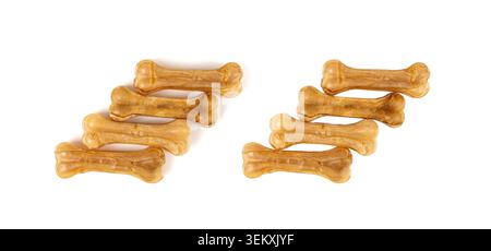 Ossa di rawhide isolate, cibo da masticare per cani con collagene, kibble secco pressato, trattamenti dentali canini naturali di lunga durata con forma ossea su sfondo bianco Foto Stock