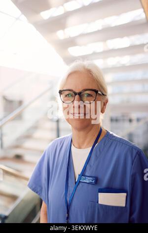 Ritratto di donna anziana sorridente operatore sanitario che indossa occhiali da vista in ospedale Foto Stock