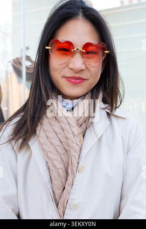Ritratto ravvicinato di una donna asiatica felice che indossa eleganti occhiali rossi a forma di cuore Foto Stock