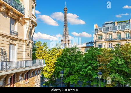 Descrizione: Splendida vista della storica Torre Eiffel che si innalza sopra le classiche case residenziali di Parigi, Francia, catturata in una vibrante giornata di sole con Foto Stock