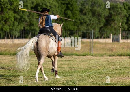 Pilota femminile che pratica Doma Vaquera con Garrocha nell'arena equestre spagnola Foto Stock