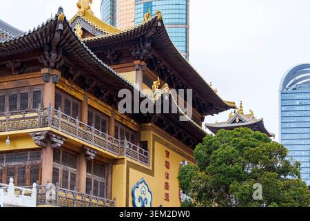 Il tempio di Jing'an, le sale gialle del tempio buddista, accanto al grattacielo di vetro, Shanghai, Cina Foto Stock