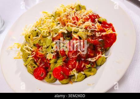 Tortellini di spinaci serviti con salsa di pomodoro e verdure Foto Stock