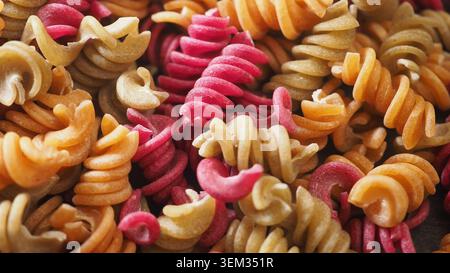 Pasta colorata a spirale con vista ravvicinata su un tavolo Foto Stock