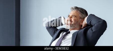Sorridente uomo caucasico di mezza età rilassarsi in ufficio, concetto di business Foto Stock