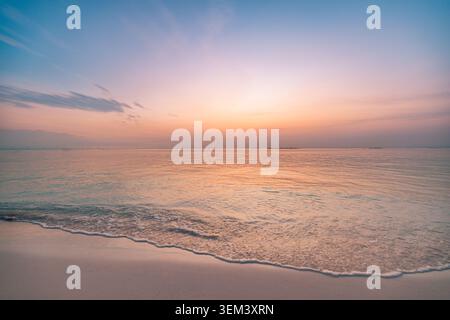 Tramonto su una spiaggia tropicale con cielo rosa pastello e turchese su un mare calmo e turchese. Paradiso di paesaggio marino estivo. Vacanze di viaggio al tramonto, vacanza oceanica su un'isola Foto Stock