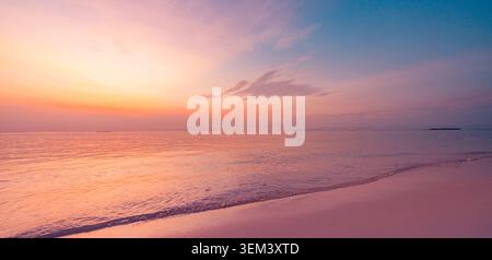 Cielo pastello morbido al tramonto sopra la riva di una spiaggia tropicale con mare rosa calmo. Ampio paesaggio marino estivo paradisiaco. Viaggio al tramonto vacanza vacanza oceano isola Foto Stock