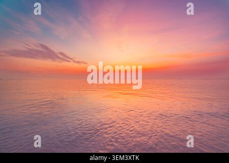 Vibrante tramonto pastello arancione su un mare tropicale calmo con nuvole morbide e orizzonte. Paesaggio marino estivo in spiaggia. Vacanze di viaggio al tramonto, vacanza oceanica, isola Foto Stock