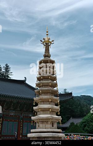 Pagoda buddista di granito a nove piani con finitura d'oro e campane appese nel cortile del Tempio di Woljeongsa, nel Parco Nazionale di Odaesan, nella Provincia di Gangwon Foto Stock