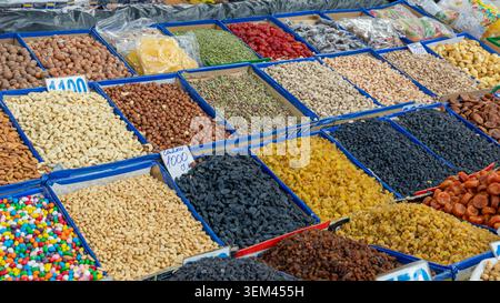Frutta secca assortita, uvetta, noci e dolci esposti in contenitori aperti in un tradizionale bancone del mercato di Osh Bazaar, Bishkek, regione di Chuy, Kirghizistan Foto Stock