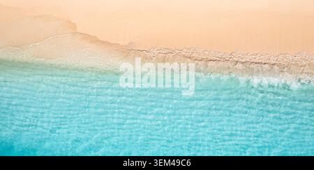 Onde turchesi dell'oceano che lambiscono una spiaggia di sabbia dorata vista aerea con drone. Acqua blu chiara, schiuma bianca. Sfondo paesaggistico tropicale paradisiaco per viaggi Foto Stock