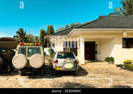 7 ottobre 2024 - Safari Vehicles and Cars parcheggiati fuori IDC Guest House a Bagamoyo, Tanzania Foto Stock