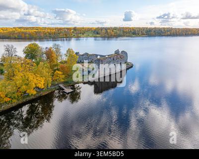 Le rovine del castello di Koknese si riflettono nelle acque del fiume Daugava durante la colorata stagione autunnale in Lettonia Foto Stock