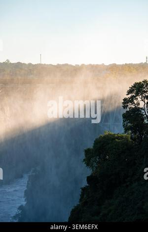 Cascate Vittoria al tramonto con Victoria Falls Bridge in nebbia Foto Stock
