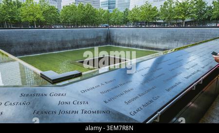 Persone al Ground Zero Memorial Manhattan per l'attacco terroristico dell'11 settembre con i nomi incisi delle vittime. Patriot Day - New York NY USA 2023-07-30 Foto Stock
