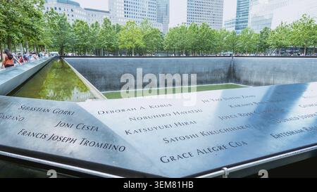 Persone al Ground Zero Memorial Manhattan per l'attacco terroristico dell'11 settembre con i nomi incisi delle vittime. Patriot Day - New York NY USA 2023-07-30 Foto Stock