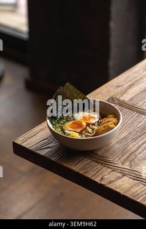 Ciotola di ramen giapponese su un rustico tavolo di legno Foto Stock