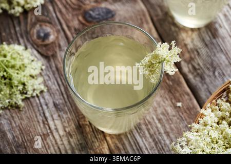 Un bicchiere di limonata fatta in casa con sciroppo di fiori di sambuco su un tavolo di legno Foto Stock