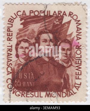 ROMANIA - 1953 giugno 18: 55 divieto di francobollo rosso-marrone raffigurante tre donne determinate di diverse etnie schierate fianco a fianco in una posizione eroica e lungimirante. La figura centrale è affiancata da due compagni, che rappresentano la solidarietà globale delle donne lavoratrici. Sullo sfondo, grandi bandiere ondeggiano in modo prominente, tra cui una bandiera con il martello e l'emblema comunista della falce. III Congresso Mondiale delle donne, che celebra l'emancipazione femminile internazionale, la mobilitazione politica e la difesa socialista della pace mondiale sotto la guida ideologica comunista Foto Stock