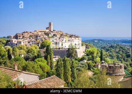 Vista panoramica del villaggio medievale di Saint-Paul-de-Vence circondato da lussureggianti alberi verdi, Provenza, Francia Foto Stock