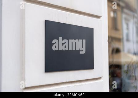 Insegna vuota montata a parete su una facciata di un negozio contemporaneo, ideale per il branding aziendale e l'identità dell'ufficio Foto Stock