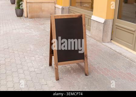 Insegna vuota in legno A telaio sul marciapiede posizionata all'esterno di un punto vendita, ideale per menu di ristoranti e promozioni caffè Foto Stock