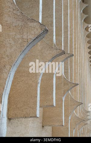 Primo piano di archi geometrici ripetuti su una facciata in stucco beige, che mostra la tradizionale architettura uzbeka nell'Asia centrale con linee forti, tex Foto Stock