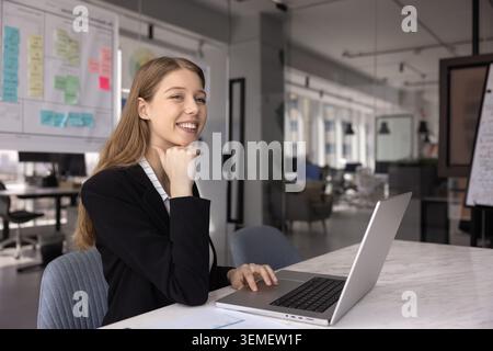 Giovane donna d'affari degli anni '30 che lavora in un ufficio moderno Foto Stock