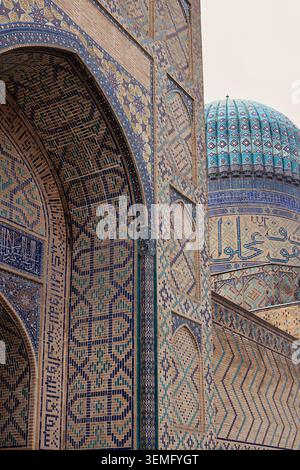 La facciata della moschea Bibi-Khanym è decorata con cupola turchese e piastrelle ornate a Samarcanda. Intricati motivi a mosaico islamico sull'arco del portale e sul tamburo Foto Stock