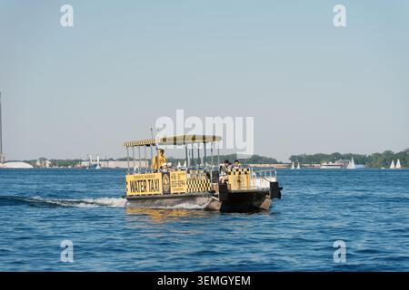 Toronto, Canada - 4 giugno 2026: Yellow Water taxi Boat sul lago Ontario con passeggeri e barche a vela distanti Foto Stock