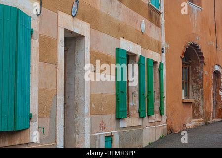 Case e persiane colorate nel villaggio di Roussillon in Provenza Francia Foto Stock
