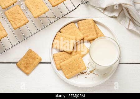 Gustosi biscotti con un bicchiere di latte su fondo di legno bianco Foto Stock