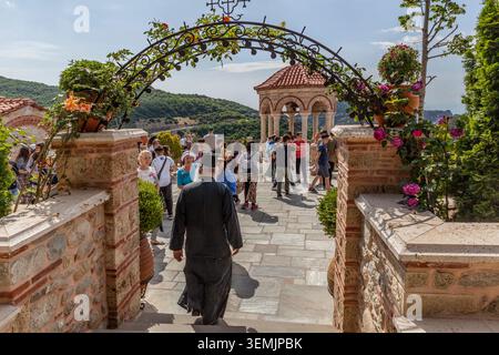 Monaco greco-ortodosso che cammina tra i turisti al monastero di Varlaam, arroccato sulle formazioni rocciose di Meteora, Grecia Foto Stock