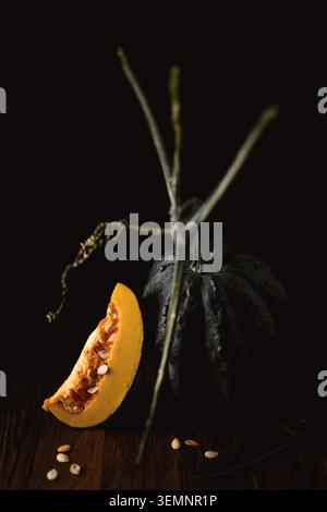 Zucca di Butternut a fette aperte con cucchiaio di legno e semi posti su un vecchio tavolo di legno. Vista dall'alto stagionale con verdure autunnali ed elementi di cottura naturali Foto Stock