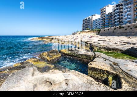 Sliema, Malta - 16 maggio 2025: Vista delle famose terme romane di Sliema, piscine in pietra naturale lungo la costa mediterranea, rinomate per la ba Foto Stock