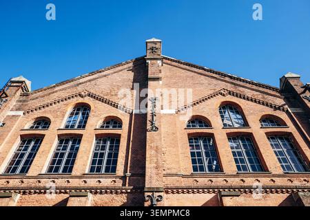 Storico edificio industriale in mattoni con grandi finestre ad arco e dettagli decorativi in muratura ad Amsterdam, Paesi Bassi Foto Stock