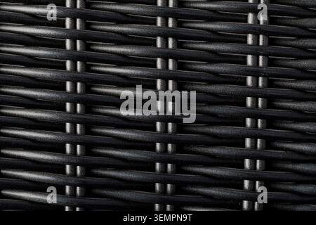 Materiale in rattan sintetico scuro che forma una superficie con trama stretta Foto Stock