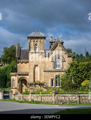 Una stretta prospettiva verticale che mette in risalto i dettagli in pietra ornati e la distinta torre della villa all'italiana Foto Stock