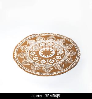 Tappeto circolare in fibra naturale realizzato in iuta o sisal, caratterizzato da un'intricata stampa geometrica bianca ispirata al mandala con motivi tribali ed etnici Foto Stock