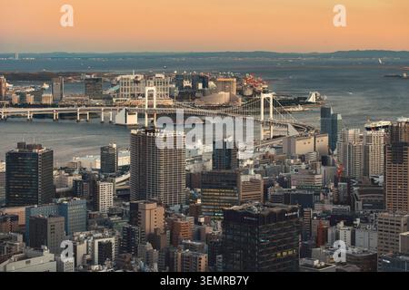 Ampia vista sopraelevata dello skyline della città di Tokyo che guarda verso la baia di Tokyo e il Ponte dell'Arcobaleno al tramonto, Giappone Foto Stock