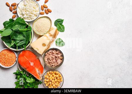 Alimenti di origine di calcio. Prodotti naturali contenenti calcio su sfondo bianco, vista dall'alto, spazio di copia. Gli alimenti ricchi di calcio comprendono sesamo, noci, pesce, Foto Stock